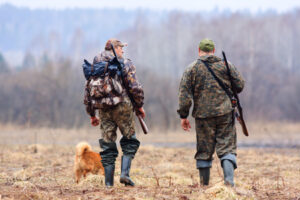 two men walking with dog hunting